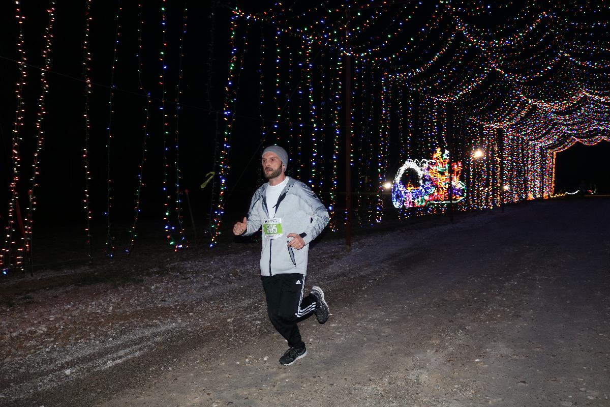 man running through Christmas lights